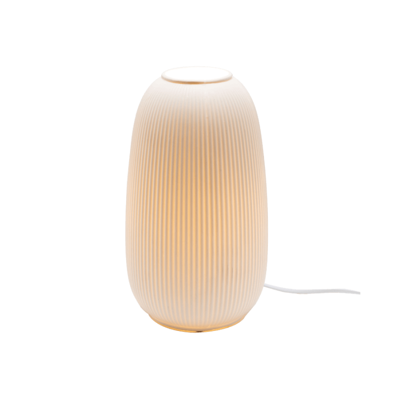 Lampe à poser en porcelaine allumée, diffusant une lumière chaude et élégante.