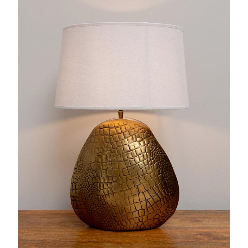 Lampe à poser avec pied doré effet peau de crocodile dans un intérieur moderne.