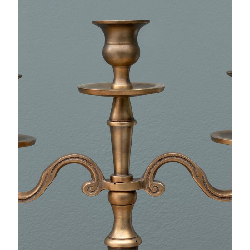 Détail des lignes majestueuses et des finitions du candélabre doré.