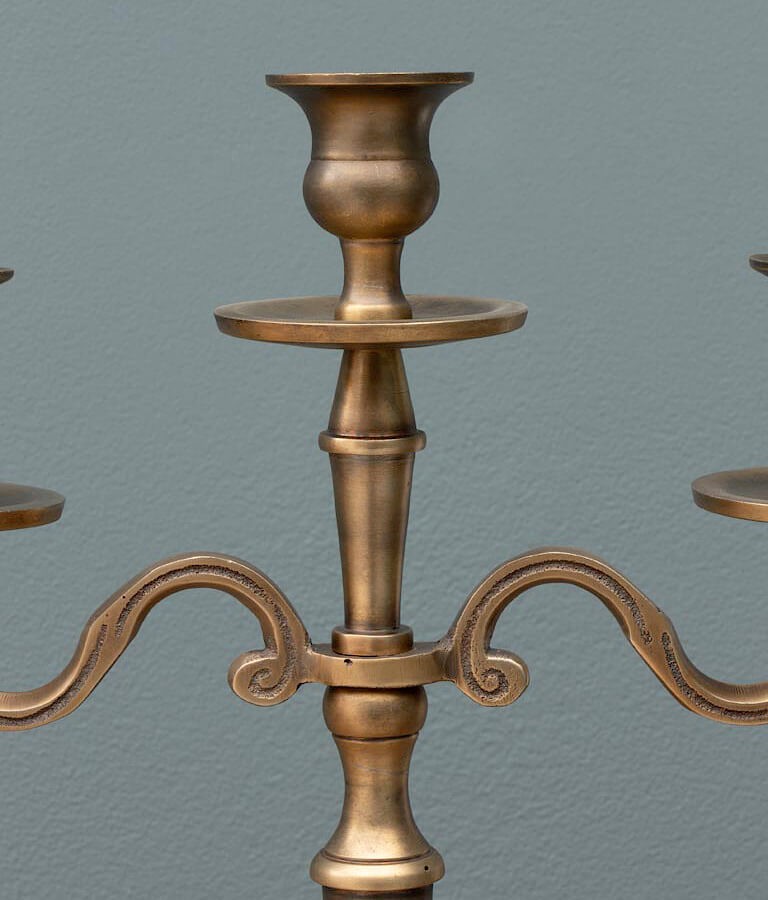 Détail des lignes majestueuses et des finitions du candélabre doré.