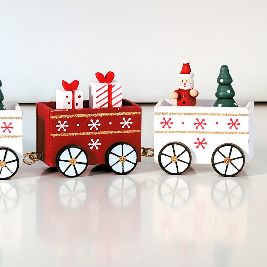 Train de Noël décoratif, wagons rouges et blancs avec motifs de flocons.