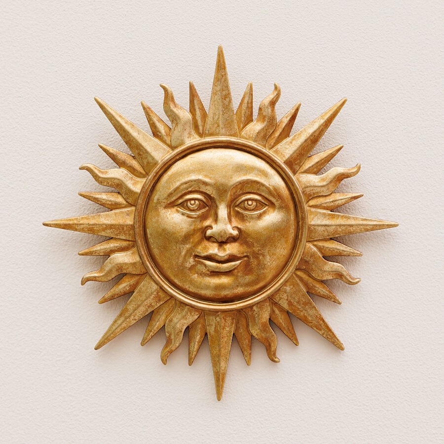 Décoration Ex-Voto Soleil en résine dorée vue de face, accrochée sur un mur de couleur beige clair.