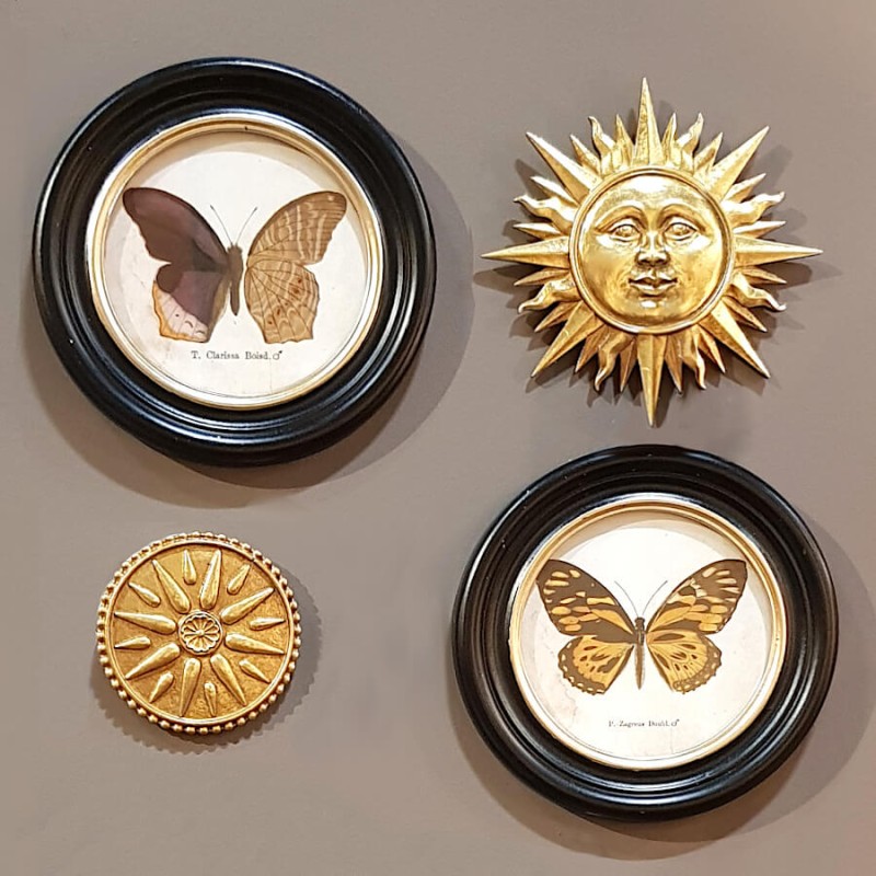 Idée de composition murale avec deux Ex-Voto Soleils Dorés, encadrés de papillons naturalisés et d'une petite rosace dorée.