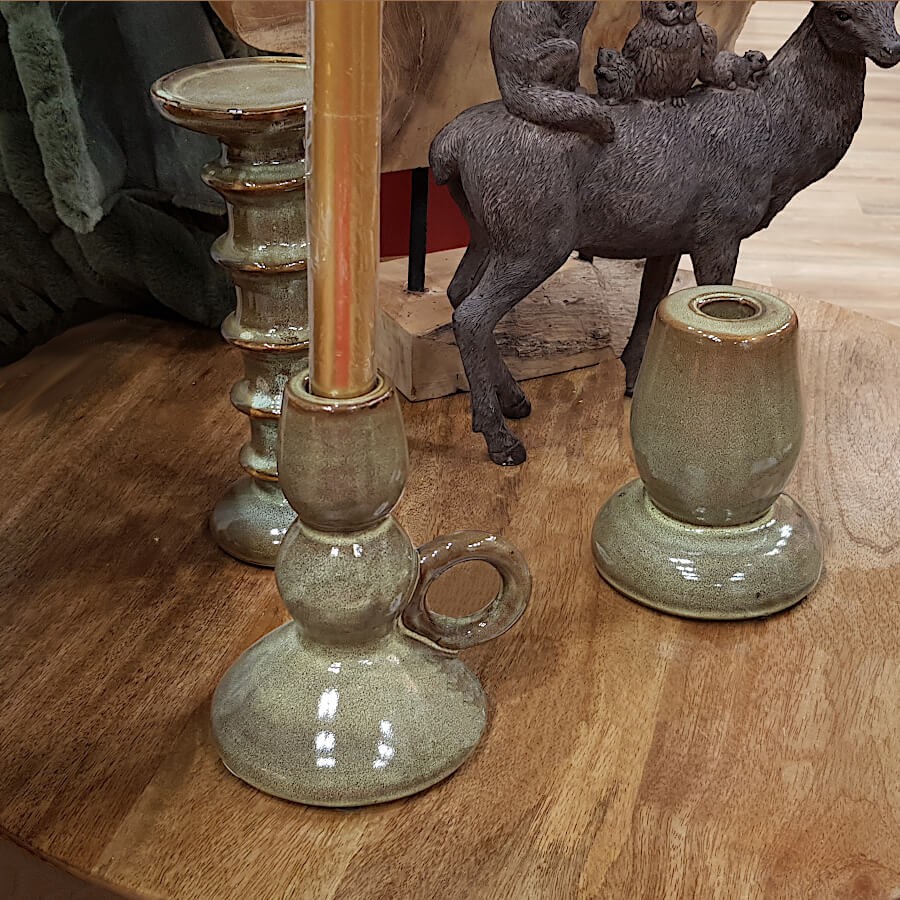 Bougeoir en céramique kaki dans un décor brut et chaleureux, ambiance intimiste.