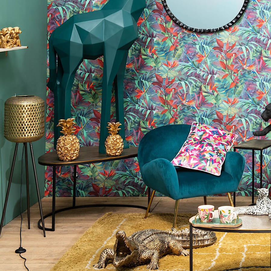 Lampadaire bohème chic intégré dans un salon exotique avec fauteuil en velours bleu.