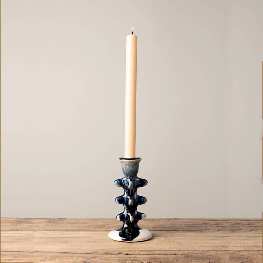 Bougeoir en céramique torsadé avec une bougie chandelle blanche.