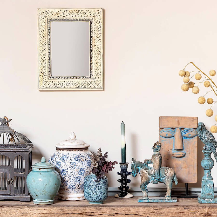 Bougeoir bleu et beige en céramique sur une étagère bohème chic.