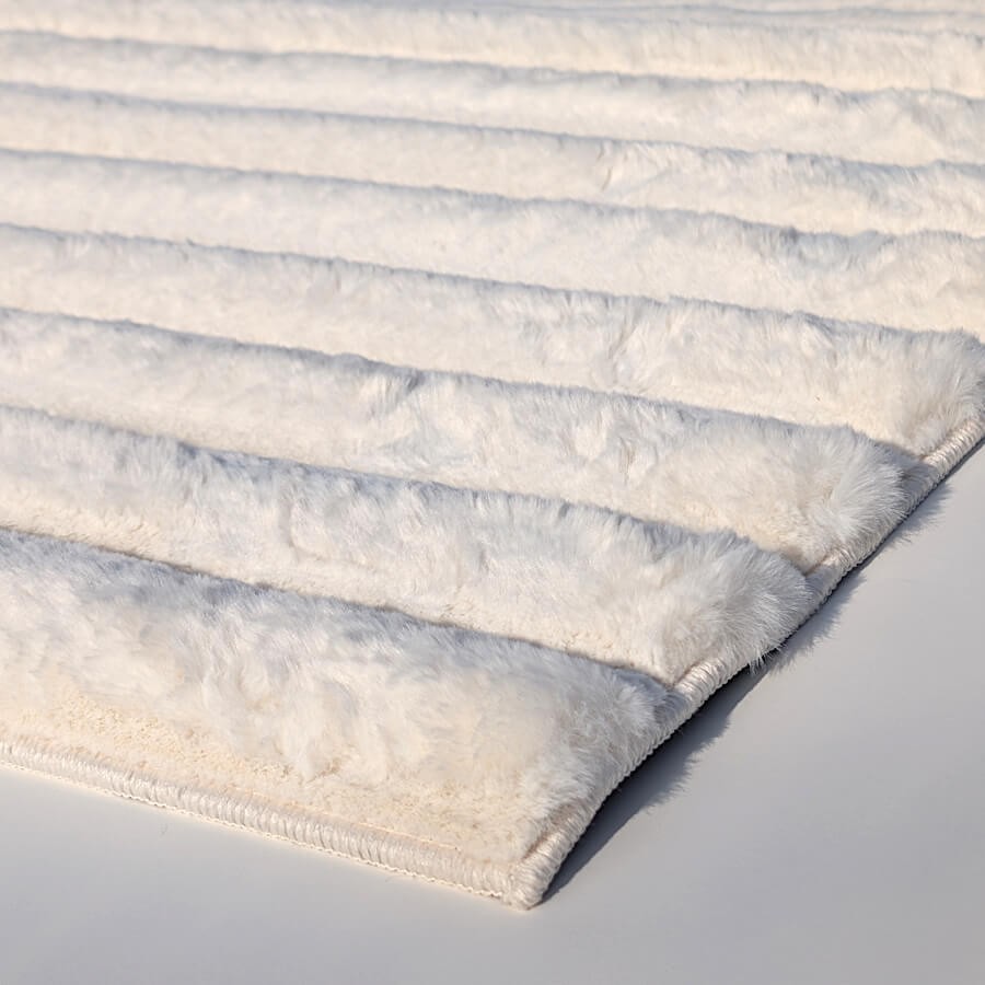 Détail du relief à rayures et de la fibre moelleuse en polyester extra doux.