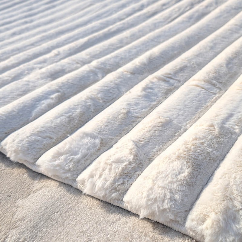 Texture luxueusement moelleuse et confort tactile du tapis blanc à lignes.