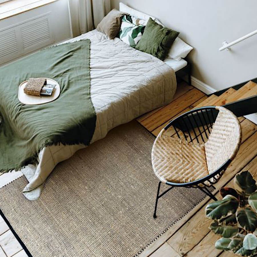 Tapis en jute utilisé comme descente de lit pour une ambiance de chambre zen.