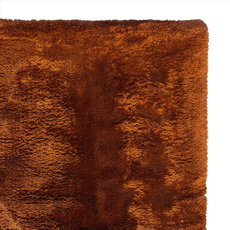 Focus sur la fibre ultra douce et le coloris taupe profond du tapis.