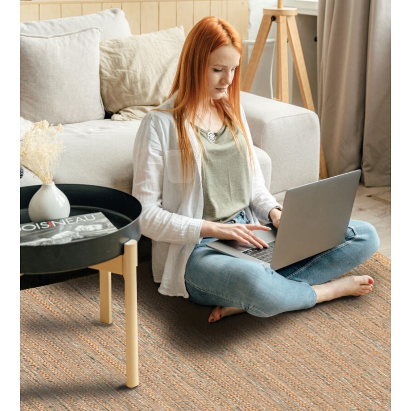 Femme assise sur le tapis d'intérieur naturel et confortable, pour un espace de travail cosy.