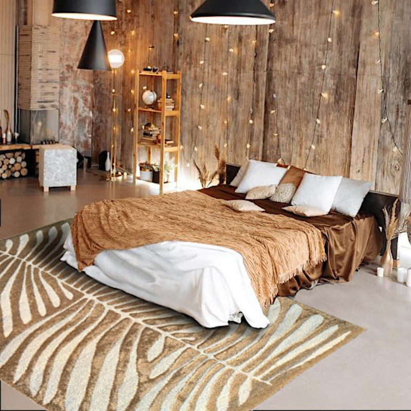 Tapis beige à motif feuillage utilisé en descente de lit dans une chambre au style chaleureux.