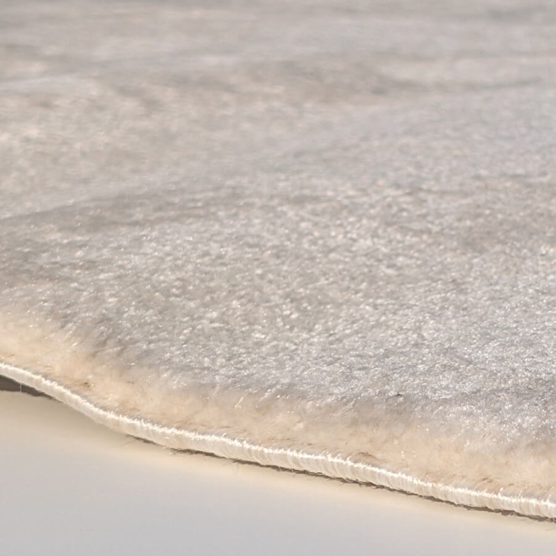 Vue sur l'épaisseur du velours (1-2 cm) et la finition soignée du tapis effet marbre.