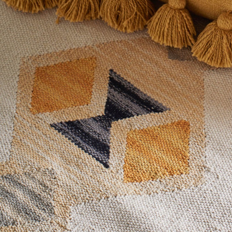 Détail du tissage en coton et des franges artisanales jaunes.