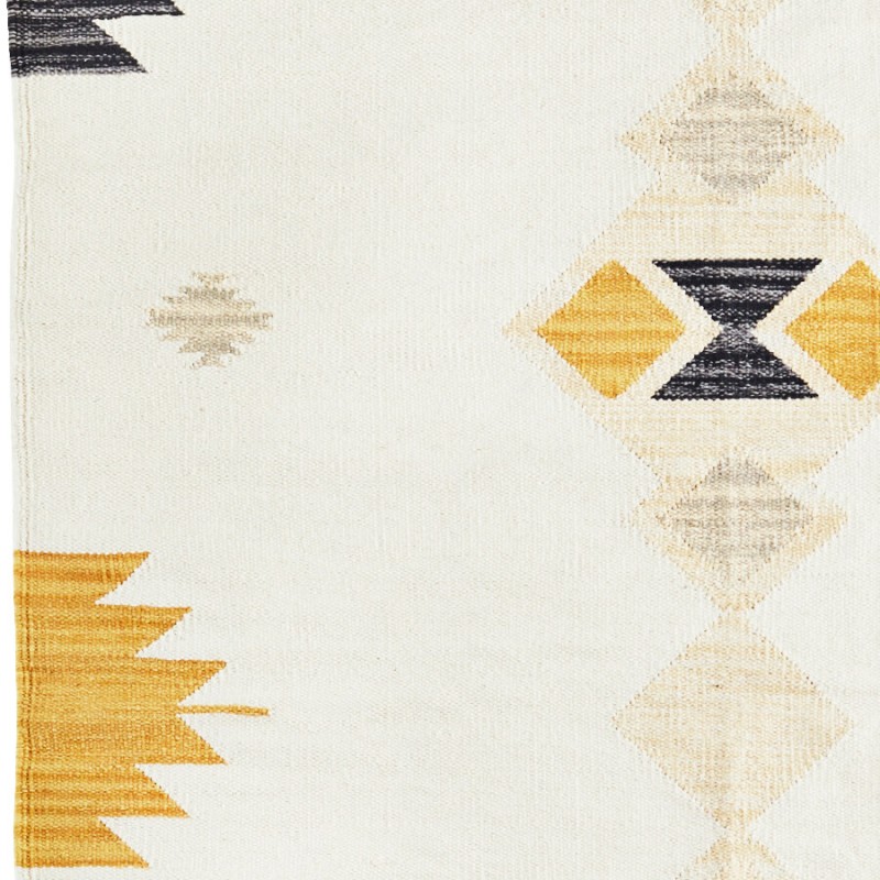 Focus sur le losange géométrique noir et jaune sur fond beige.