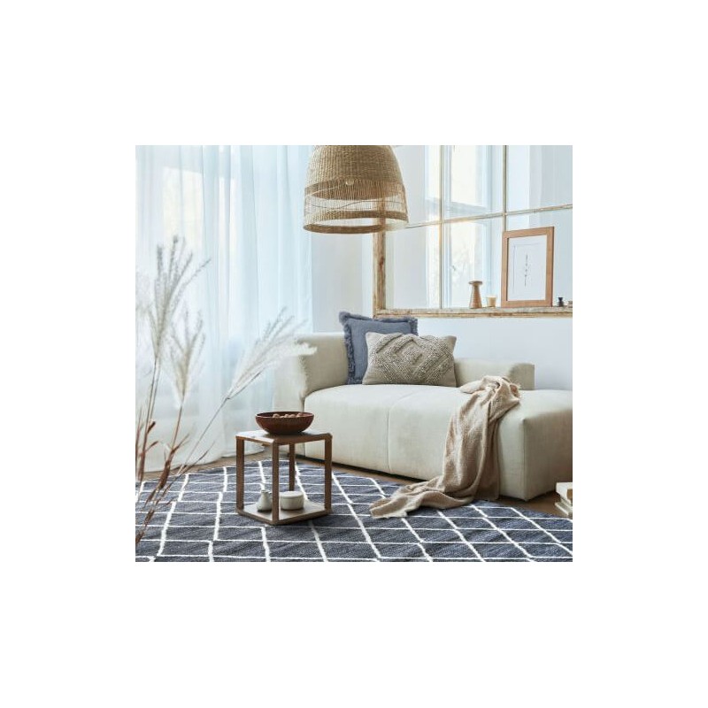 Tapis gris à croisillons blancs structurant un espace de détente ou un salon lumineux.