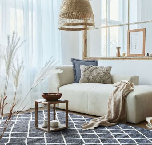 Tapis gris à croisillons blancs structurant un espace de détente ou un salon lumineux.