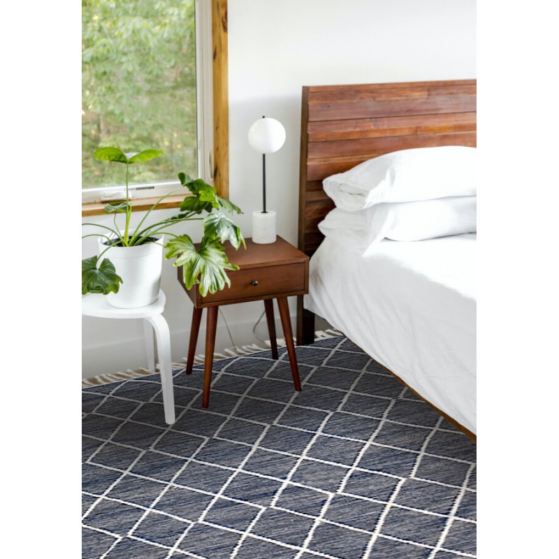 Tapis gris foncé à losanges écrus, utilisé en descente de lit, dans une ambiance cosy.