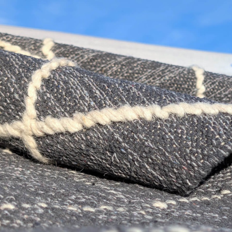 Vue sur la souplesse du tissage et le contraste des matières.