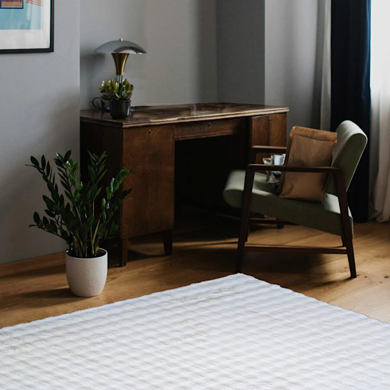 Tapis blanc à relief apportant du confort dans un coin bureau.