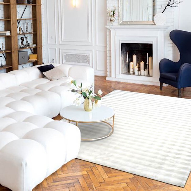 Grand tapis blanc structurant un salon moderne et lumineux.