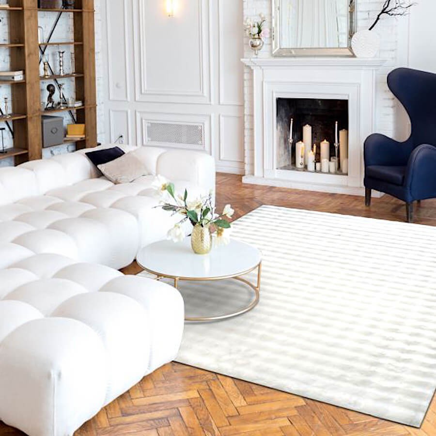 Grand tapis blanc structurant un salon moderne et lumineux.
