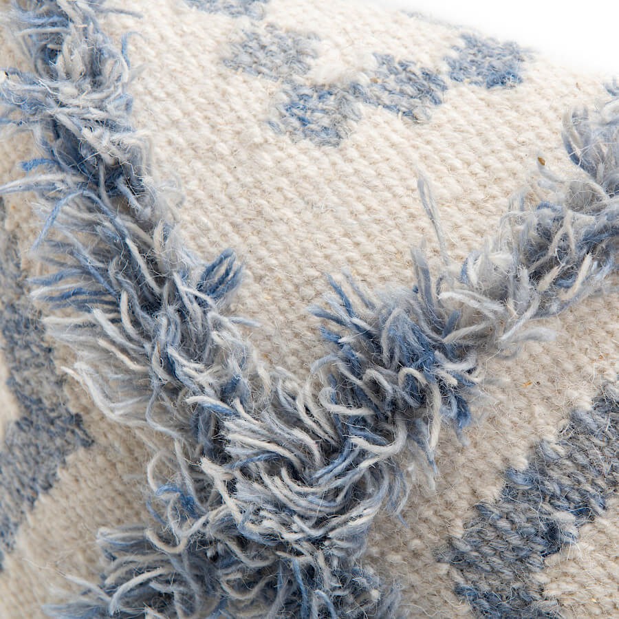 Zoom sur le motif losange tufté et le mélange des fibres naturelles.