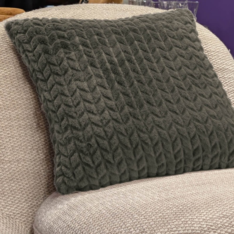 Le coussin kaki intégré sur un fauteuil crème pour une ambiance cocooning et sobre.