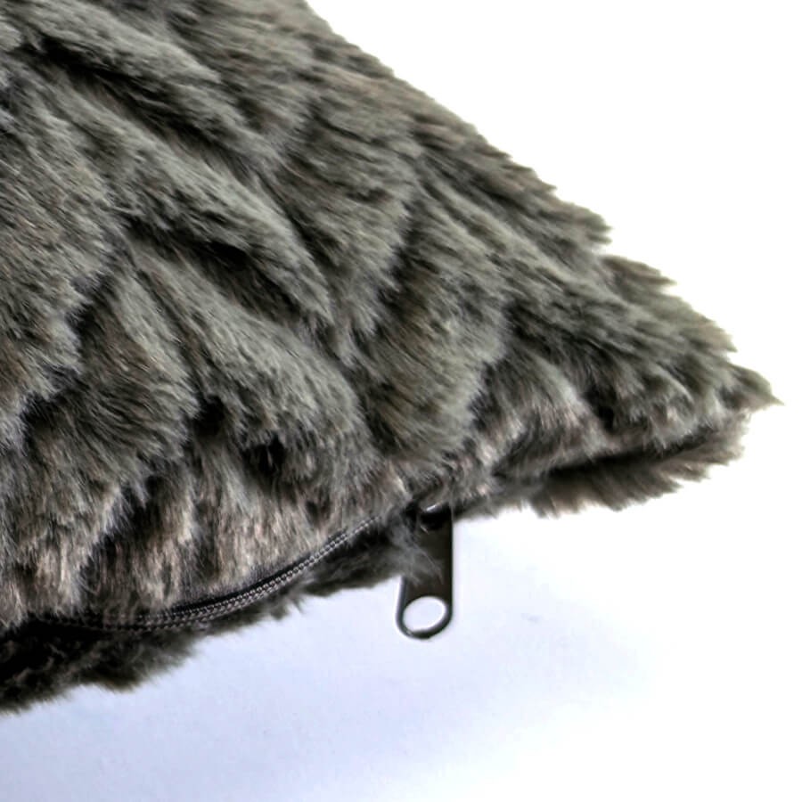 Vue rapprochée de la tirette de la fermeture éclair du coussin sur le modèle kaki.