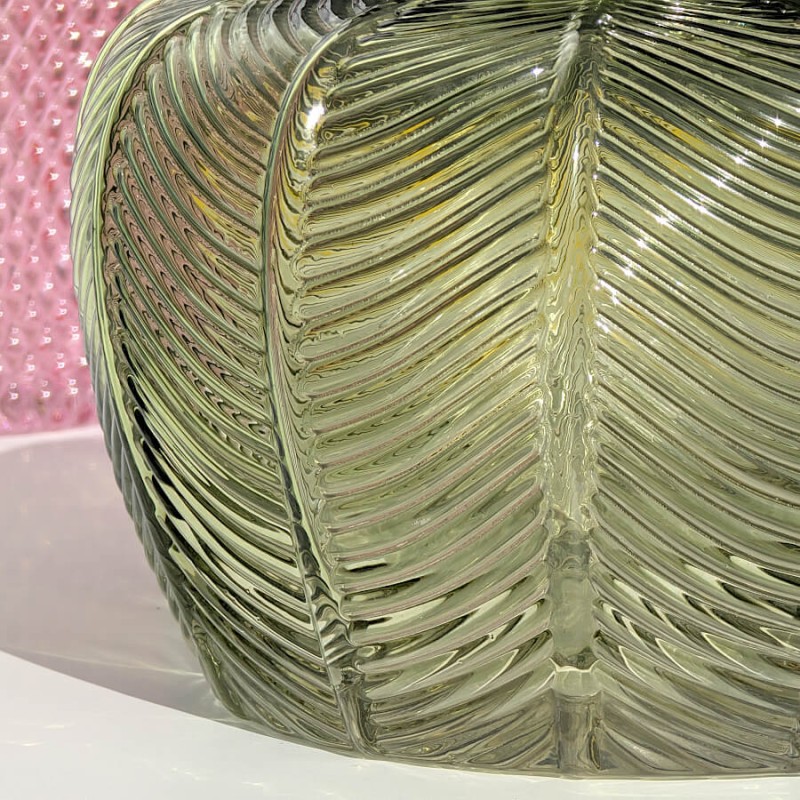 Gros plan sur les nervures du motif végétal gravées dans le verre vert.