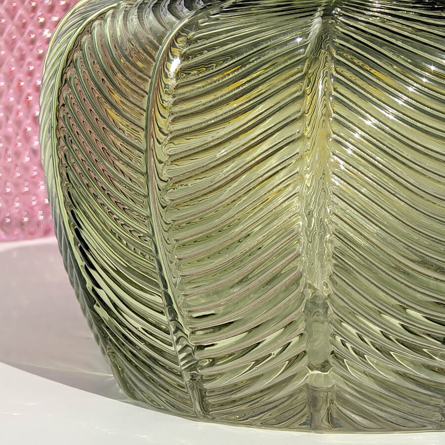 Gros plan sur les nervures du motif végétal gravées dans le verre vert.