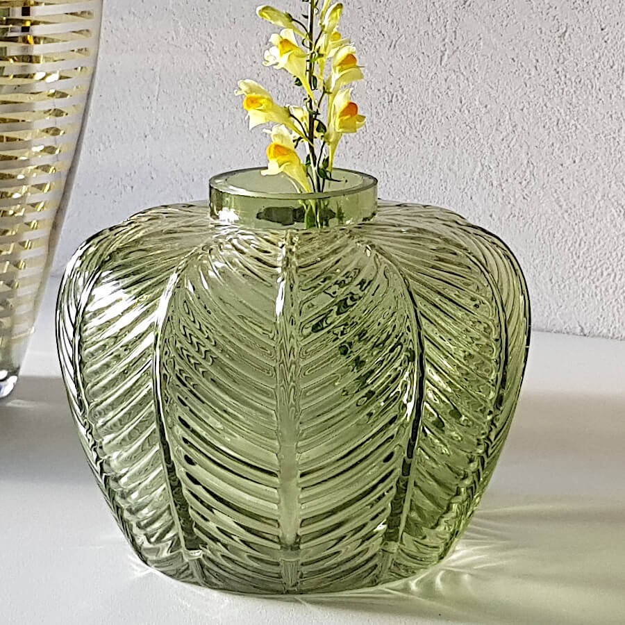 Mise en scène du vase décoratif avec une fleur jaune soulignant le col étroit.