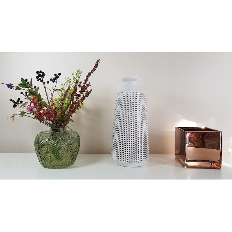 Présentation du vase sur une étagère blanche avec d'autres objets déco design.