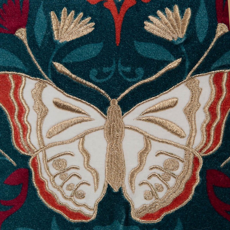 Détail des broderies artisanales des ailes du papillon en fils blancs et dorés.