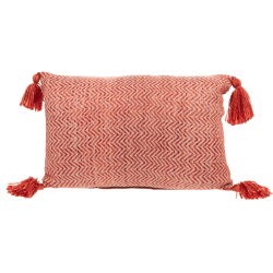 Coussin rectangulaire tissé corail et beige avec quatre pompons aux angles.