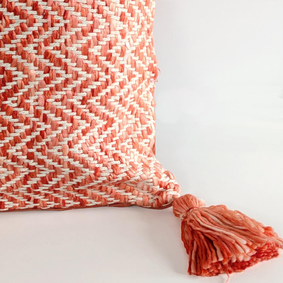 Détail du pompon artisanal bicolore et du tissage serré en coton.