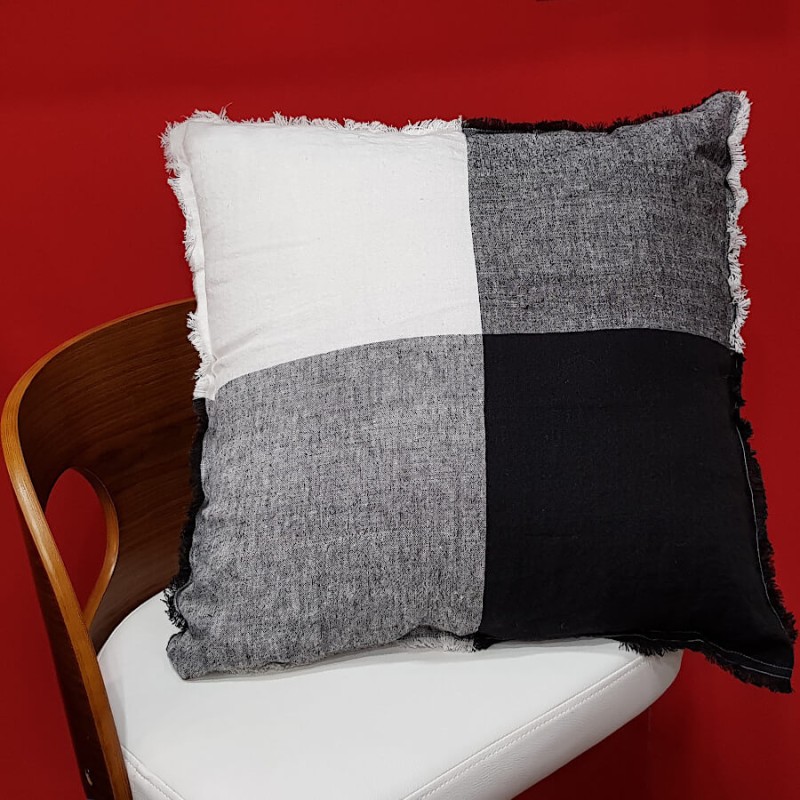 Coussin en lin damier posé sur une chaise design blanche pour un look moderne.