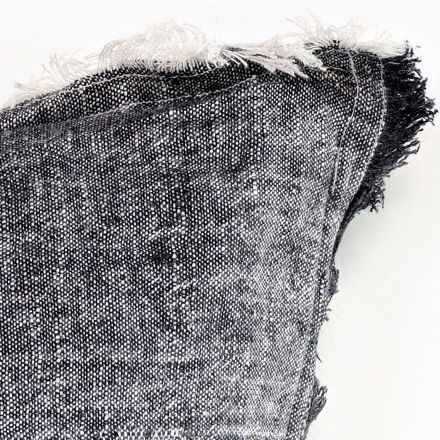 Détail des bordures effilochées apportant une finition brute et naturelle.