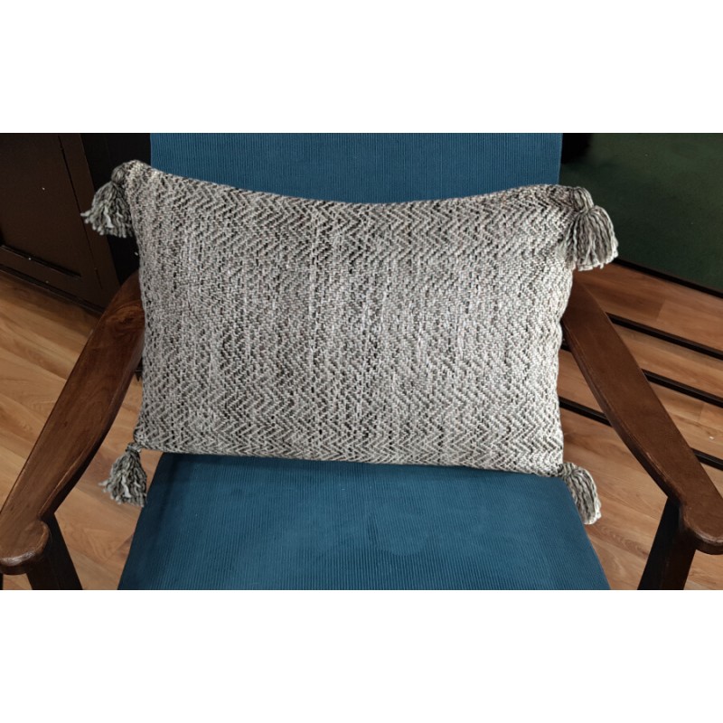 Coussin gris texturé posé sur un fauteuil bleu pour une ambiance moderne.