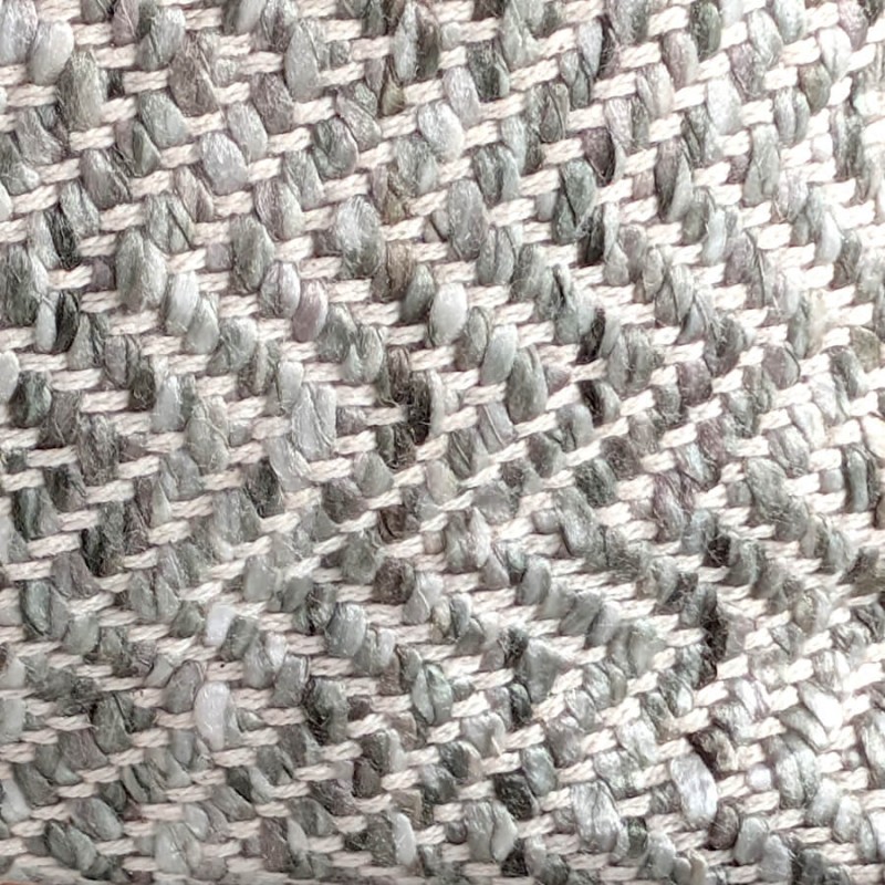 Gros plan sur le relief du tissage en chevrons aux fils gris et blancs.