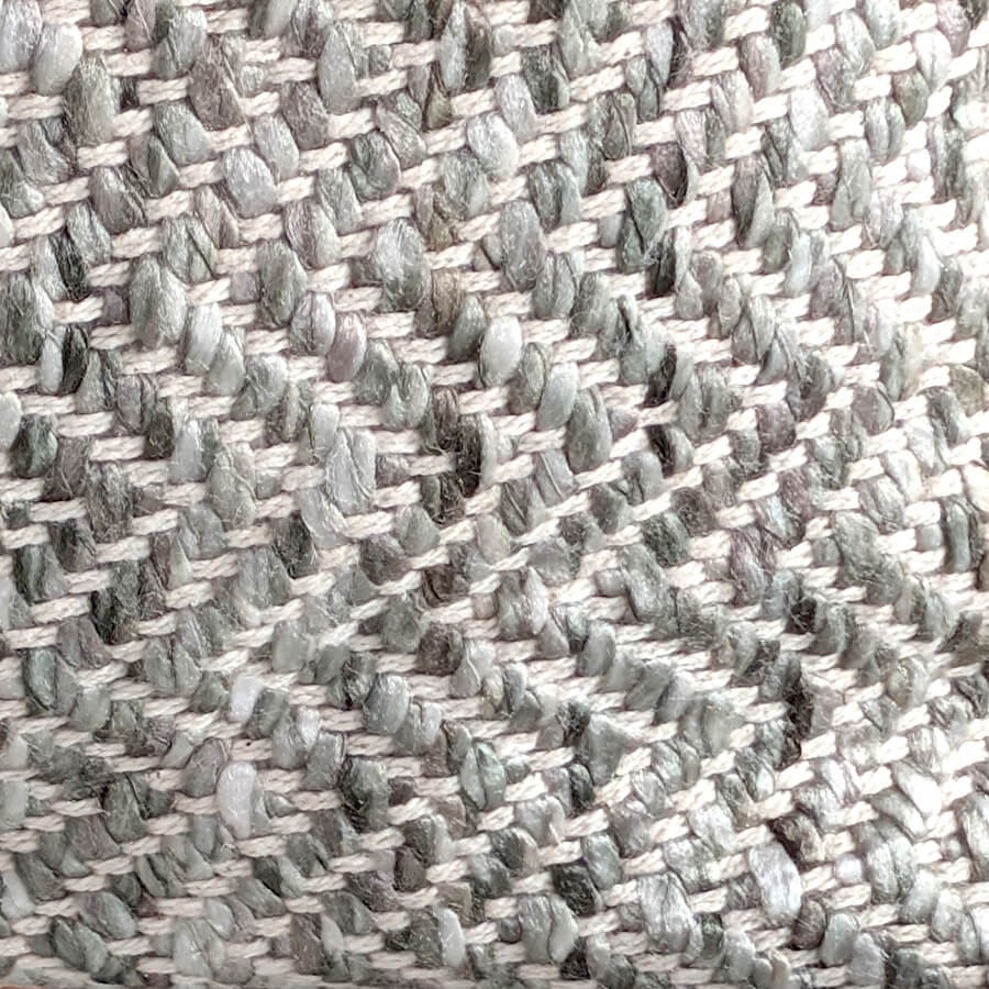 Gros plan sur le relief du tissage en chevrons aux fils gris et blancs.