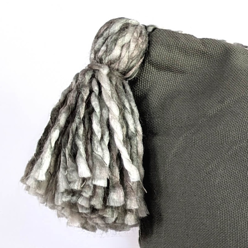 Vue rapprochée de la finition du pompon et de l'épaisseur du tissu tissé.