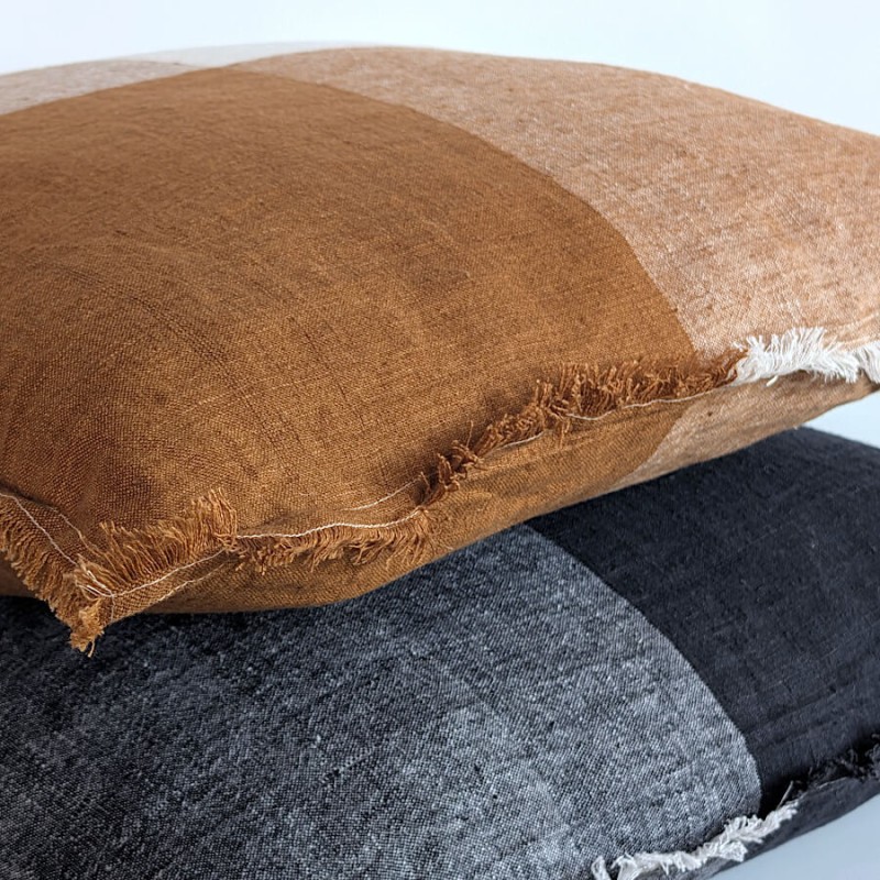 Gros plan sur la finition des bords effilochés et l'épaisseur du lin.