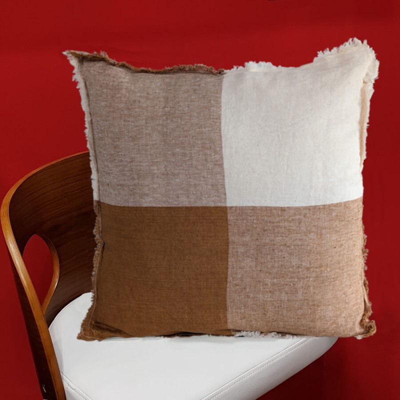 Coussin lin brun posé sur une chaise blanche pour une décoration épurée.