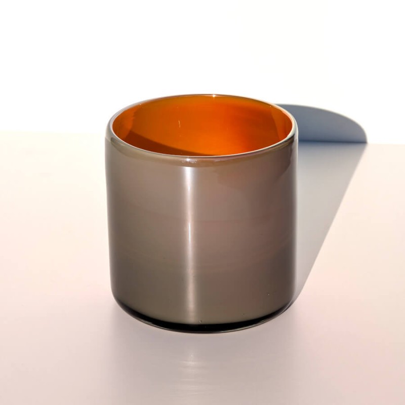 Vue de face du photophore cylindrique, gris à l'extérieur, orange à l'intérieur.