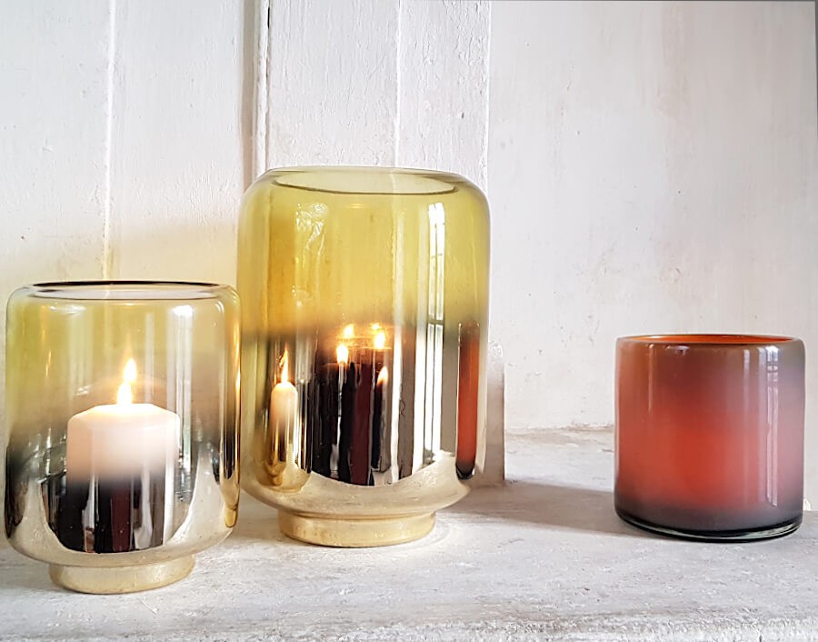 Photophores en verre allumés créant une lumière chaude.