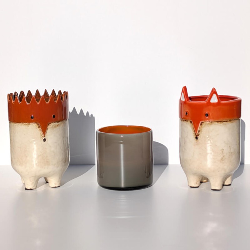 Composition de photophores et pots renard et hérisson stylisés.