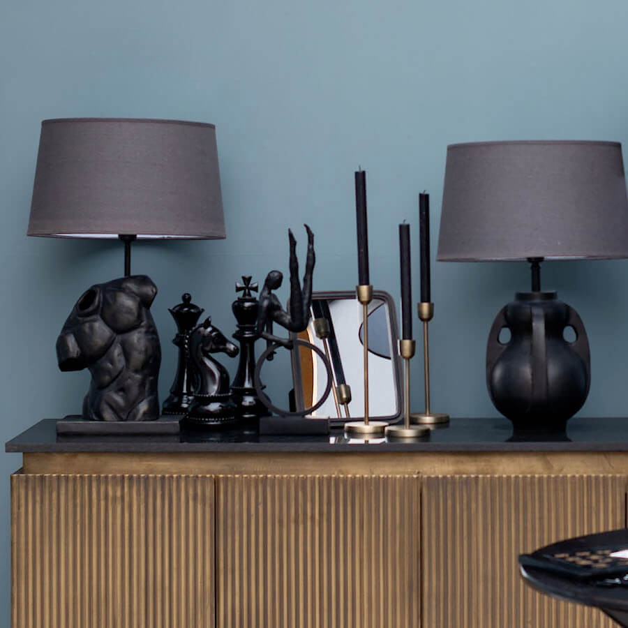 Accumulation de bougeoirs dorés sur un meuble de salon moderne.