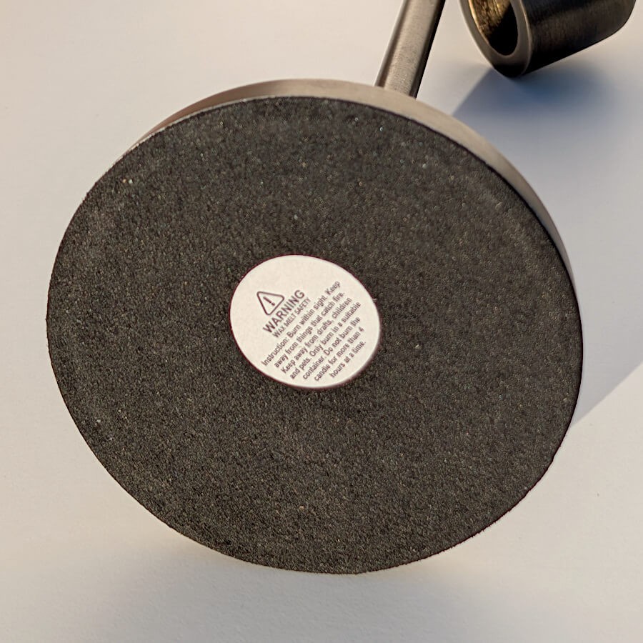 Revêtement de protection antidérapant sous le bougeoir stable avec les instructions de sécurité.